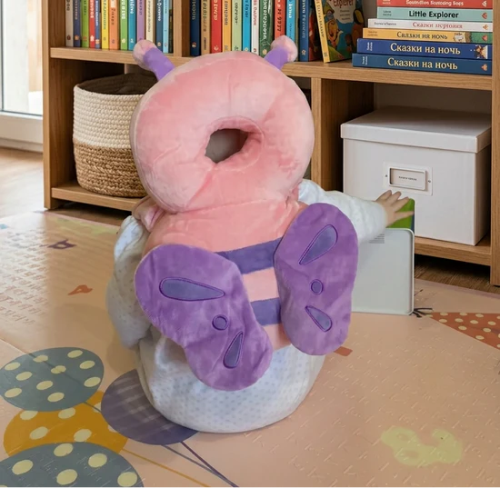 Child wearing a pink butterfly head protector near a bookshelf